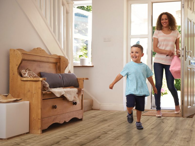 Excited Boy Returning Home From School With Mother